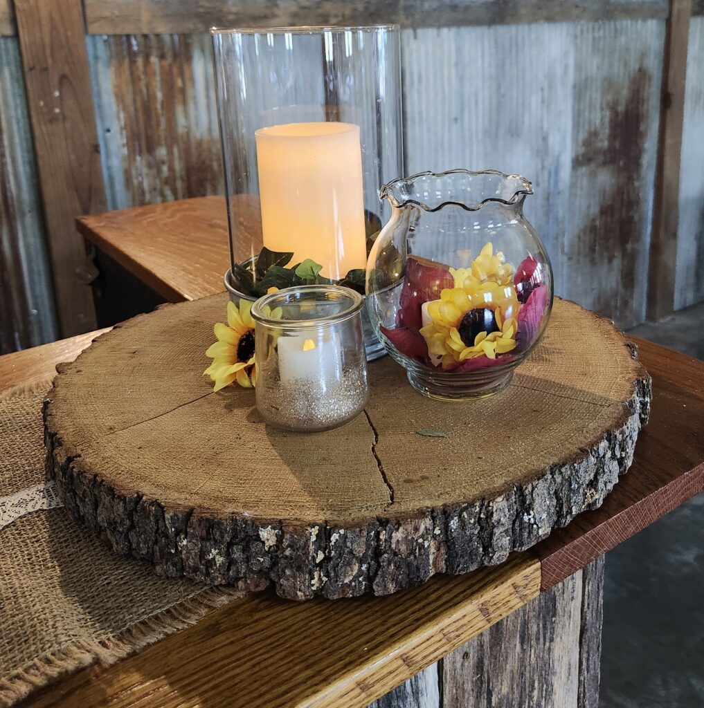 Country Charm Venue reception table décor featuring a sunflower centerpiece, burlap runner, and glowing candles