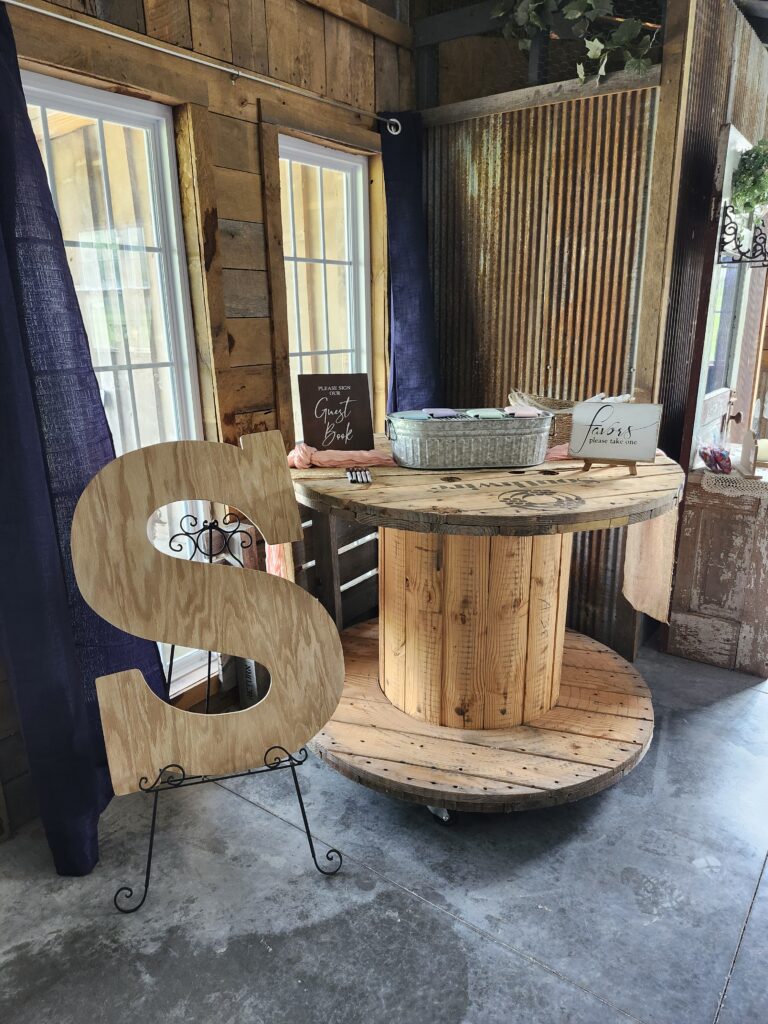 Custom wooden initial guestbook built by venue owner husband for rustic wedding