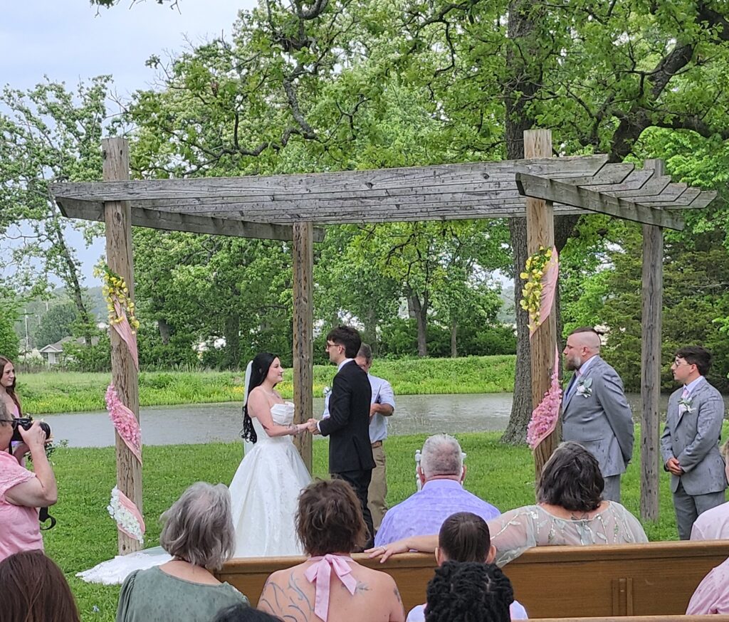 Outdoor wildflower wedding inspiration ceremony at Country Charm Venue pond arbor
