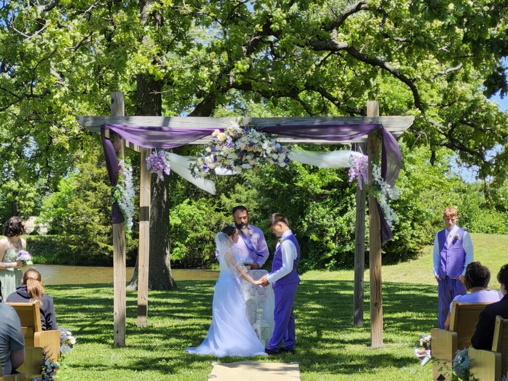 Outdoor spring wedding ceremony at the pond arbor at Country Charm Venue