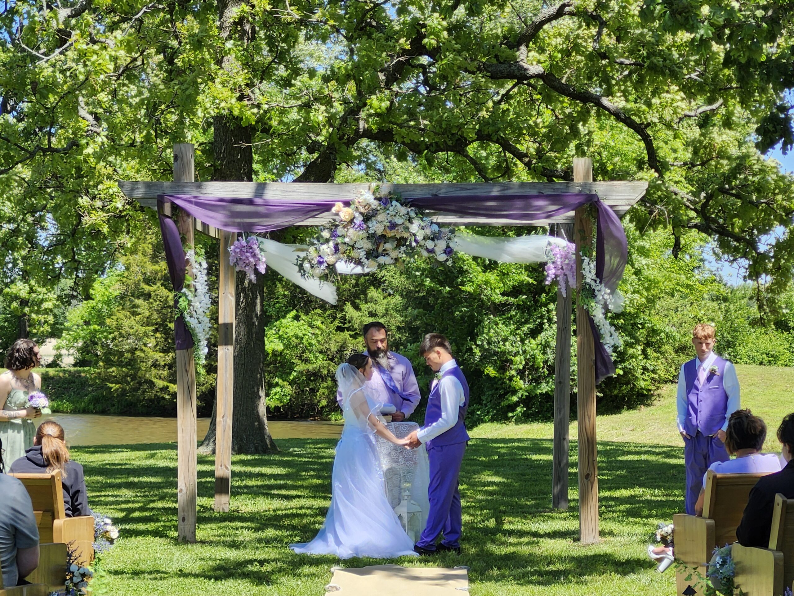Outdoor spring wedding ceremony at the pond arbor at Country Charm Venue