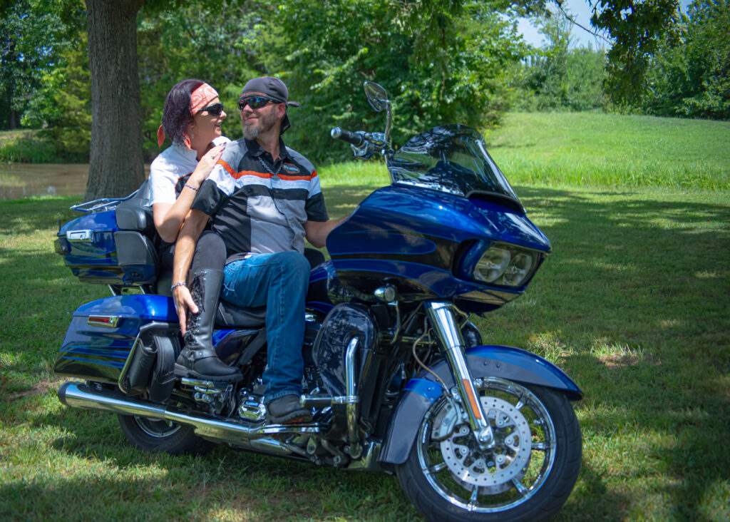 Couple with motorcycle parked near the pond on venue grounds