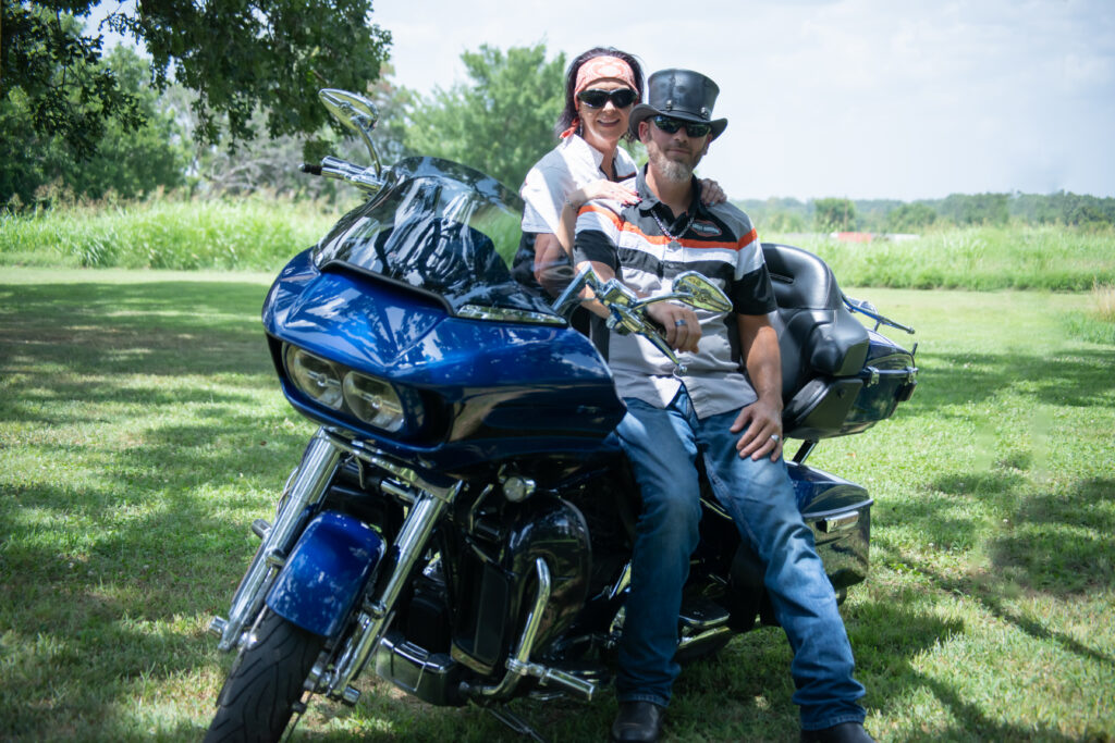 Couple on motorcycle set against open rolling fields